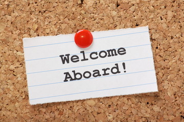 Welcome Aboard! note pinned to a cork notice board
