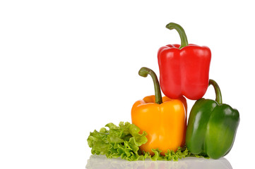 Red Green and Yellow peppers on salad leaf isolated on white bac