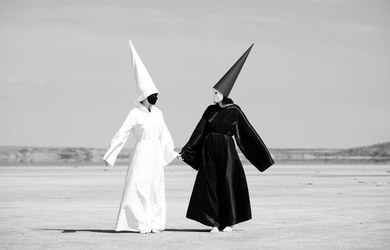 Two people in black cloak and white cloak talking. Artwork