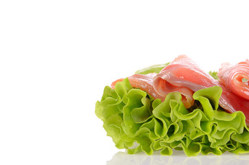 Sliced salmon fish on green salad isolated on white background