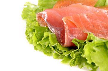 Sliced salmon fish on green salad isolated on white background