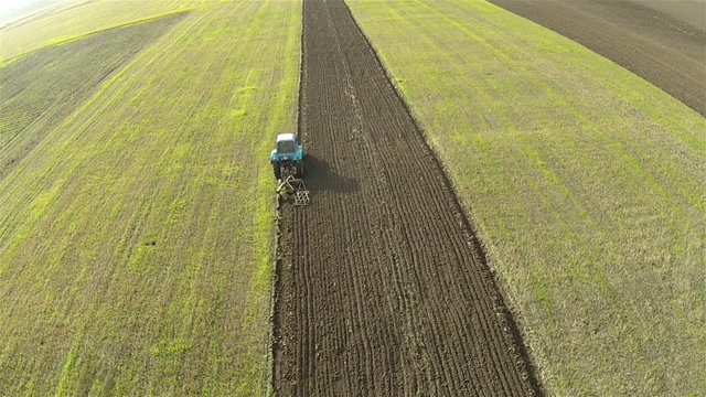The tractor plows a field.  Aerial