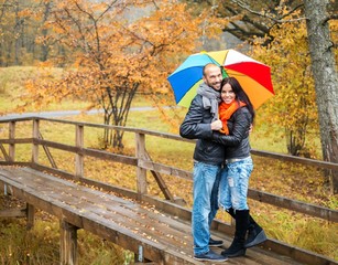 Happy middle-aged couple with umbrella outdoors