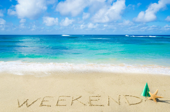 Sign "Weekend" on the sandy beach
