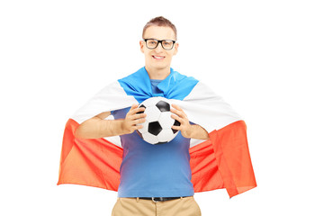 Young male fan holding a soccer ball and flag of Holland