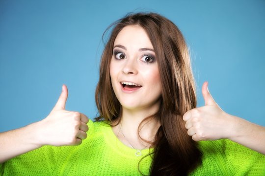 Happy smiling woman with thumbs up gesture
