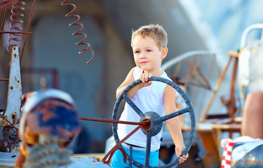 cute child boy pretends driving an imaginary car