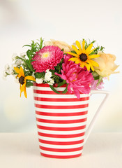 Beautiful bouquet of bright flowers in color mug,