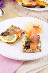 Salmon sandwiches on plate  on wooden table close-up
