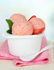 Tasty ice cream scoops in bowl, on wooden table