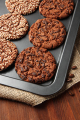 Homemade cookies on dripping pan, on wooden background