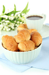 Tasty croissants and cup of coffee isolated on white