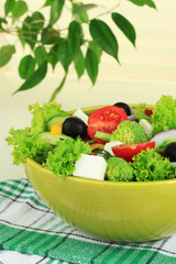 Greek salad on plate on table on light background