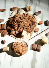 Cocoa powder in spoon on wooden table