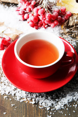 Still life with viburnum  tea in cup, berries and snow,