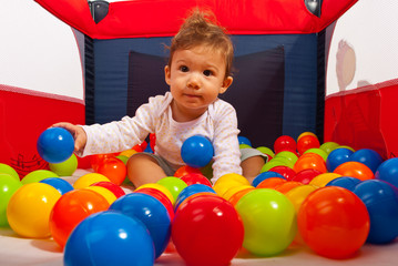 Obraz premium Baby in playpen with balls