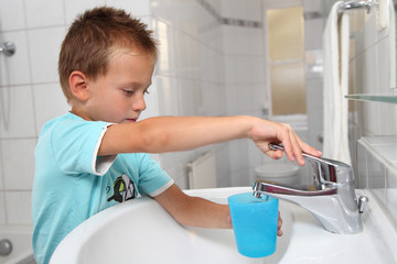 Junge mit Zahnputzbecher