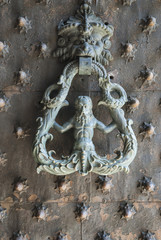 Old door with knocker in the form of mythical figure