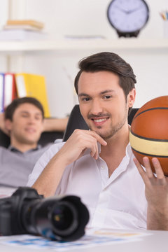 Man holding basketball ball and looking at camera.