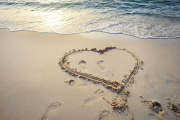 Heart written on sand.