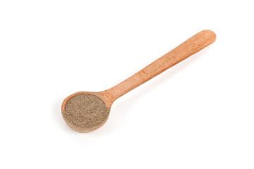 milled black pepper in wooden spoon