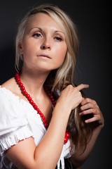 Obraz premium Folk woman in folklore clothes braiding a plait
