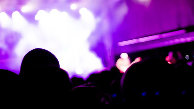 De-focused footage of young people dancing at rock concert