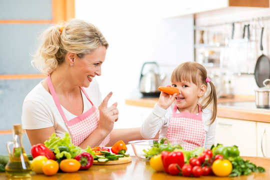 mother and her child preparing healthy food and having fun