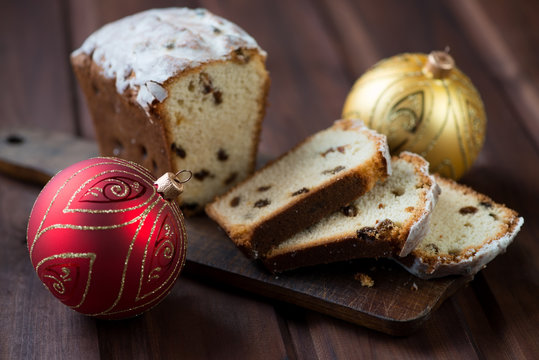 Christmas fruit-cake and xmas balls, wooden background