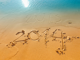 New Year 2014 concept-written in sand on the beach sand