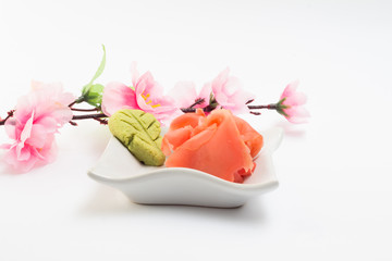 Ginger and wasabi on white plate with sakura