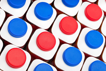 dairy products bottles stand in rows, bright covers