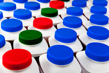 dairy products bottles stand in rows, bright covers