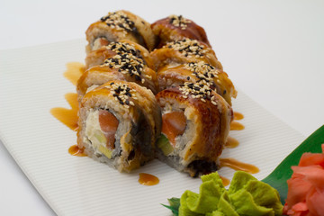 Canada sushi roll on white plate with ginger and wasabi