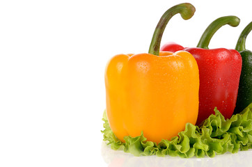 Red Green and Yellow peppers on salad leaf isolated on white bac