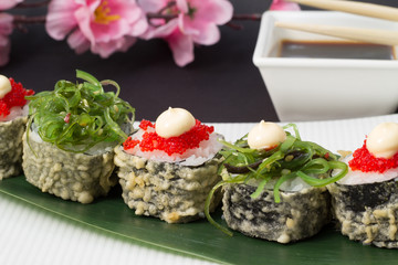 Sushi roll in tempura with salad chuka with red tobiko