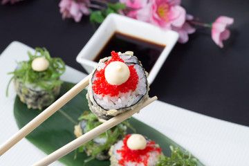 Sushi roll in tempura with salad chuka with red tobiko