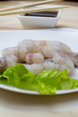 Fototapeta na wymiar Raw shrimp on plate with salad and soy sauce