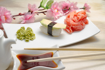Avocado sushi nogoro in chopsticks with soy sauce