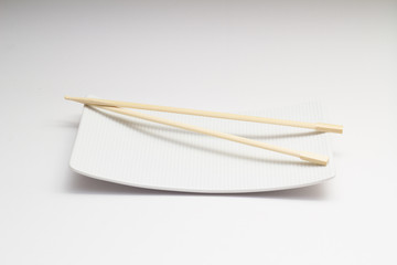 Chopsticks on white dish