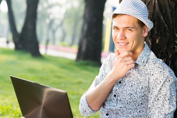 Fototapeta premium young man working in the park with a laptop