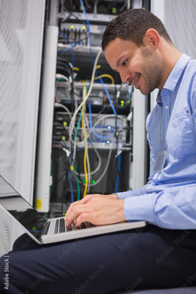 Poster Man using laptop in front of servers
