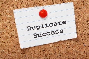 Duplicate Success on a paper note pinned to a cork board