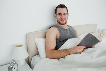 Smiling man reading a novel