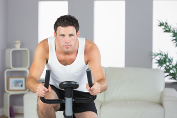 Plakat Handsome sporty man exercising on bike