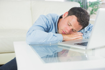 Tired casual man sleeping with head resting on table
