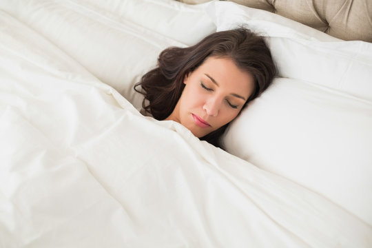 Peaceful pretty brown haired woman sleeping in her bed