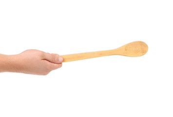 Hand holds wooden spoon.