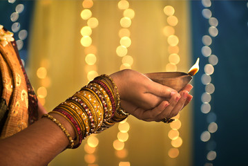 diwali festival of lights , hands holding indian oil lamp