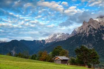 Fototapeta na wymiar hut on meadow and Karwendel mountain range by Mittenwald